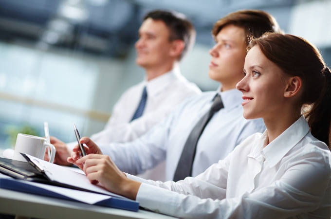 Three business people sitting at a seminar