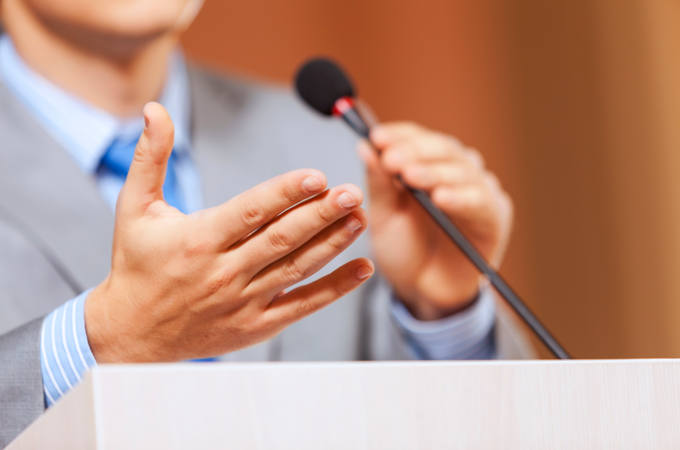 Businessman standing on stage and reporting for audience